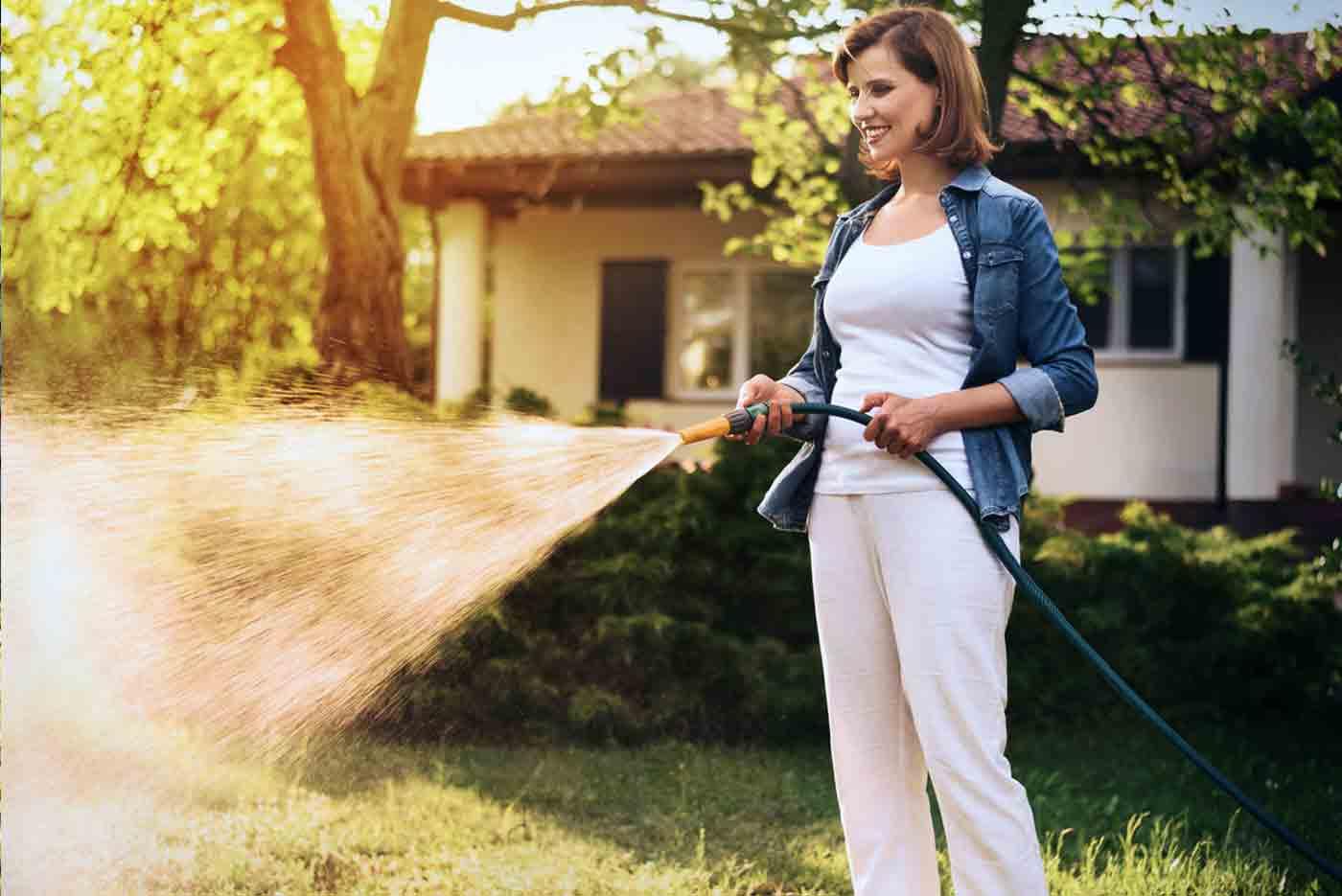 Woman watering her backyard